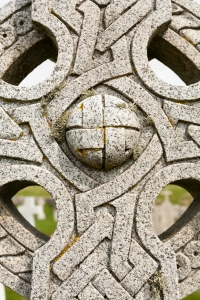 Close up showing the detail of Celtic cross grave in Barra cemetary. Moss and weathered rock visible.