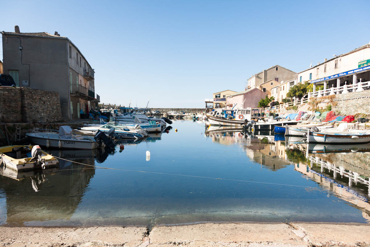 View of the harbour in the Port of Centuri in Corsica, visible are the village, and fishing vessels.